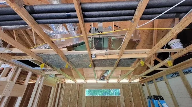 Professional HVAC technician reviewing a residential load calculation beside an outdoor air conditioning unit before installation.